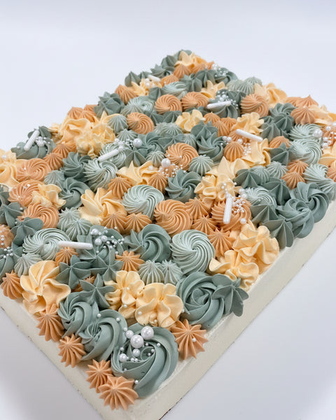 Slab cake decorated with buttercream piping in soft colours