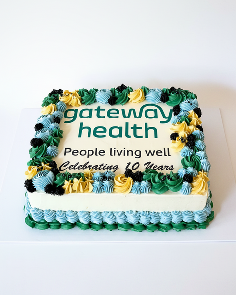 A slab cake with green and blue icing, decorated with text 'gateway health - People living well' celebrating 10 years.
