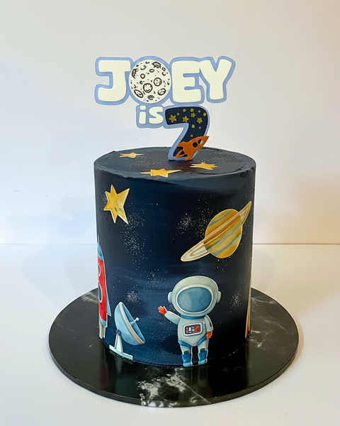 Space-themed birthday cake with astronaut, planets, and stars on a white background