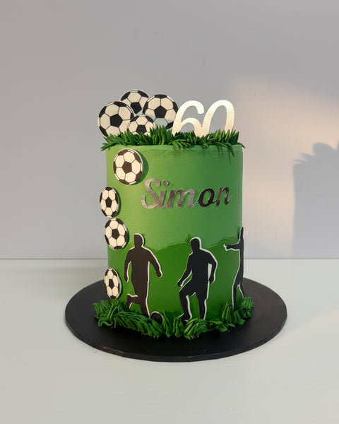 Green birthday cake with soccer ball decorations 
